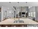 Open-concept kitchen with large island overlooking a living area with a stone fireplace and ample natural light at 11209 Flenniken Ct, Charlotte, NC 28277