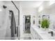 Bathroom with white tile shower, dual sink vanity, and a walk-in closet for storage at 113 Verbena Ne St # 11, Charlotte, NC 28217