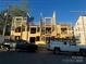 Framed townhomes show construction with lumber, blue sheathing, and power lines against a blue sky at 113 Verbena Ne St # 11, Charlotte, NC 28217