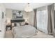 Serene bedroom featuring neutral tones, a comfortable bed, stylish lamps, and soft curtains at 113 Verbena Ne St # 11, Charlotte, NC 28217