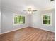 Bright bedroom featuring hardwood floors, neutral walls, and plenty of natural light from two large windows at 114 Elmwood Dr, Salisbury, NC 28147