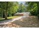 Spacious brick home with a long driveway leading to an attached garage, surrounded by lush trees at 114 Elmwood Dr, Salisbury, NC 28147