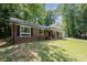 Beautiful brick home with black shutters and a charming front porch with white columns and an American flag at 114 Elmwood Dr, Salisbury, NC 28147