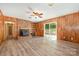 Bright living room features wood paneling, brick fireplace, and sliding doors to the patio at 114 Elmwood Dr, Salisbury, NC 28147