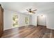 Bright living room with hardwood floors, two windows, a ceiling fan, and access to other rooms at 114 Elmwood Dr, Salisbury, NC 28147