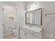 Bathroom featuring a vanity with modern sink and a toilet near a window, well-lit at 1142 Doveridge St, Charlotte, NC 28273