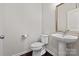 Bathroom featuring a pedestal sink, toilet, framed mirror, and hard wood floors at 1142 Doveridge St, Charlotte, NC 28273