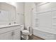 Well-lit bathroom with vanity, toilet and tub shower combination featuring white fixtures at 1142 Doveridge St, Charlotte, NC 28273