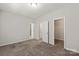 A bedroom with neutral walls, carpeted flooring, and two entryways at 1142 Doveridge St, Charlotte, NC 28273