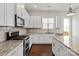 Modern kitchen featuring stainless appliances, granite countertops, and white cabinetry at 1142 Doveridge St, Charlotte, NC 28273