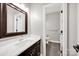 Bathroom featuring a framed mirror, a white countertop vanity, and access to a tiled toilet room at 12711 Duncourtney Ln, Charlotte, NC 28277