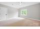 A bright bedroom featuring neutral walls, plush carpet, ceiling fan, and a window with natural light at 12711 Duncourtney Ln, Charlotte, NC 28277