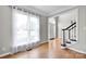 Bright living room with hardwood floors, large windows with sheer curtains and staircase at 12711 Duncourtney Ln, Charlotte, NC 28277