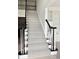 Stylish staircase with herringbone carpet runner, contrasting dark handrail, and open floor plan at 12711 Duncourtney Ln, Charlotte, NC 28277