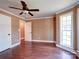Bright and open bedroom featuring hardwood floors, a ceiling fan, and three access doors at 1306 Abbey Ct, Lancaster, SC 29720
