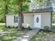 Close up of the detached building with a white door, surrounded by grass and a tree at 1306 Abbey Ct, Lancaster, SC 29720