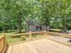 A wooden deck overlooking a private yard with mature trees and a detached outbuilding at 1306 Abbey Ct, Lancaster, SC 29720