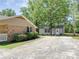Brick home with a long driveway and separate building, surrounded by mature trees and greenery at 1306 Abbey Ct, Lancaster, SC 29720