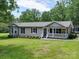 Well-maintained home with inviting front porch and lush landscaping, nestled among mature trees at 1306 Abbey Ct, Lancaster, SC 29720