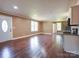 Open living space with hardwood floors, multiple windows, and kitchen with stainless steel appliances at 1306 Abbey Ct, Lancaster, SC 29720