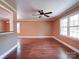 Bright living room boasting hardwood floors, a ceiling fan, and trim plus multiple large windows at 1306 Abbey Ct, Lancaster, SC 29720