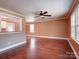 Spacious living room featuring hardwood floors, a ceiling fan, and large windows for plenty of natural light at 1306 Abbey Ct, Lancaster, SC 29720
