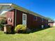 Rear exterior view of a brick home featuring a white door and green grass at 1412 Beverly Ave, Shelby, NC 28152