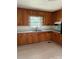 Cozy kitchen features wood cabinets, light countertops, and stainless steel sink under a window at 1412 Beverly Ave, Shelby, NC 28152