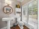 Elegant powder room with pedestal sink, stylish wallpaper, and natural light at 15 Old Stage Trl, Clover, SC 29710