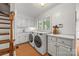 Well-lit laundry room featuring modern washer and dryer, white cabinets, and wood floors at 15 Old Stage Trl, Clover, SC 29710