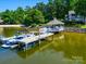 Scenic waterfront view featuring a dock, gazebo, boat, and lush trees in the background at 15 Old Stage Trl, Clover, SC 29710
