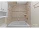 Bathroom with tiled walls, a tub, and shower; providing a functional and clean space at 1500 Lynway Dr, Charlotte, NC 28203