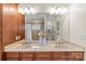 Large bathroom with a double vanity, wooden cabinets, framed mirror, and a tiled shower at 1500 Lynway Dr, Charlotte, NC 28203
