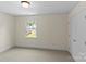Neutral bedroom features a window with backyard views and a double door closet at 1500 Lynway Dr, Charlotte, NC 28203