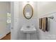 Traditional powder room with pedestal sink, oval mirror, wainscoting and convenient outdoor access at 1500 Lynway Dr, Charlotte, NC 28203