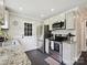 Well-lit kitchen features stainless steel appliances, tile backsplash, granite counters, and gray cabinets at 1505 Wimbleton Woods Dr # 5, Fort Mill, SC 29708
