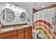 Charming bathroom features a double sink vanity, decorative mirrors, and a colorful patterned shower curtain at 15737 Agincourt Dr, Huntersville, NC 28078