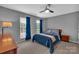 Comfortable bedroom features a cozy bed, dark wood furnishings, neutral carpet, and natural light from the windows at 15737 Agincourt Dr, Huntersville, NC 28078
