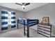Neutral bedroom boasts a dark wood bunk bed, ceiling fan, grey walls and ample natural light through large windows at 15737 Agincourt Dr, Huntersville, NC 28078