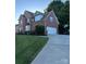 Brick home featuring an attached garage, basketball hoop, and well-maintained lawn at 15737 Agincourt Dr, Huntersville, NC 28078