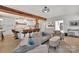Bright, open living room boasts wood beam, sleek white cabinets, island with bar stools, and comfortable seating at 15737 Agincourt Dr, Huntersville, NC 28078
