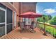 Outdoor dining area with a table and chairs under a red umbrella on a spacious wooden deck for entertaining at 15737 Agincourt Dr, Huntersville, NC 28078