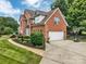 Brick home with a two-car garage, well-maintained landscaping, and a paved driveway with a basketball hoop at 15737 Agincourt Dr, Huntersville, NC 28078
