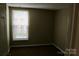 This is a carpeted bedroom with window and neutral walls at 1604 Arlyn Cir # E, Charlotte, NC 28213