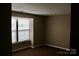 Carpeted bedroom features a large window bringing in natural light at 1604 Arlyn Cir # E, Charlotte, NC 28213