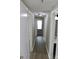 Hallway featuring wood laminate floors, white trim, and doors leading into rooms at 1604 Arlyn Cir # E, Charlotte, NC 28213
