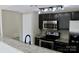 Updated kitchen features granite countertops, black cabinets, and stainless steel appliances at 1604 Arlyn Cir # E, Charlotte, NC 28213