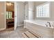 Bright bathroom featuring a soaking tub, tile floors, and a glass block window at 1648 Jonesberry Dr, Rock Hill, SC 29732