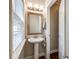 Cozy powder room with a pedestal sink, framed mirror, and natural light at 1648 Jonesberry Dr, Rock Hill, SC 29732