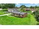 Aerial view of a single-Gathering brick home with lush green landscaping and mature trees at 1735 Hollandale Dr, Gastonia, NC 28054